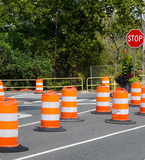 Traffic control cones lining a roadway with vehicles passing safely.